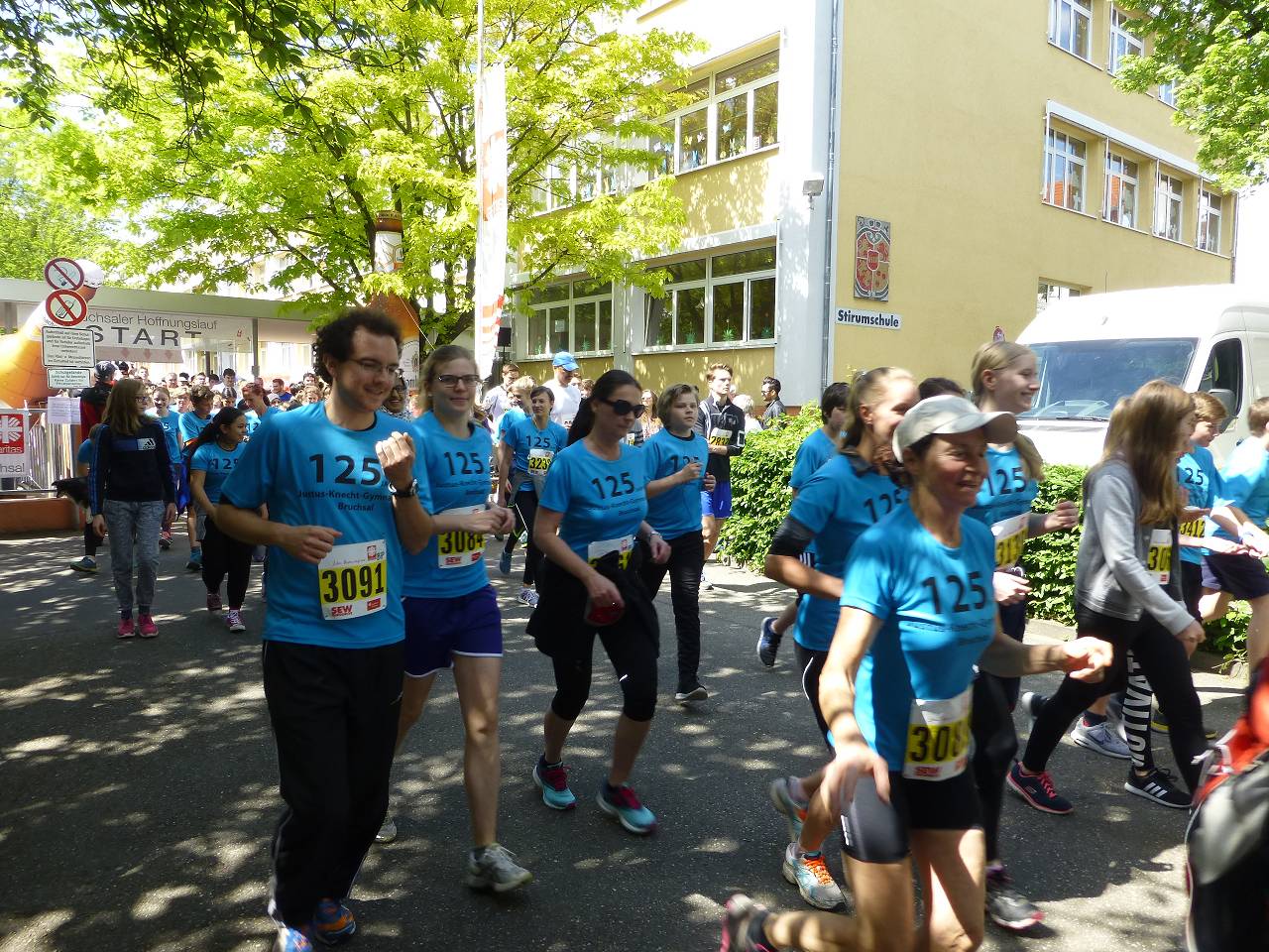 Start des Hoffnungslaufs 2017 - Läuferinnen und Läufer in blauen T-Shirts vor der Strumschule